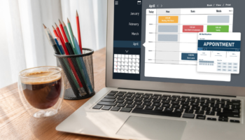 The best employee scheduling software for small businesses shown on a laptop on a wooden table in a sunny office showing easynote