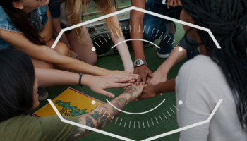 Young members of a community touching hands in cirrcle as company engagement okrs are a big part of any company with the help of easynote