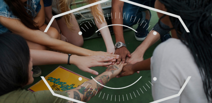 Young members of a community touching hands in cirrcle as company engagement okrs are a big part of any company with the help of easynote