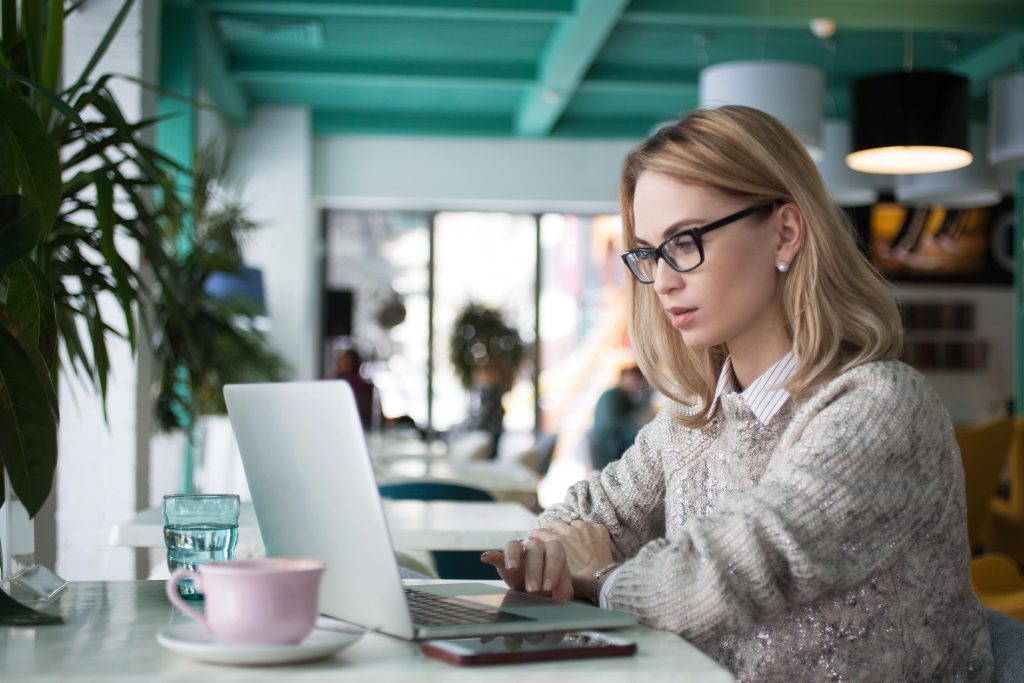 A project manager sits at her home office and looks at her monitor to see which tasks need to be finished today using easynote