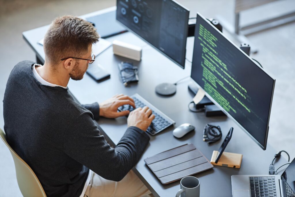 A male entrepreneur sitting at a desk in his office researching Entrepreneur Operating System and using easynote as his time management tool