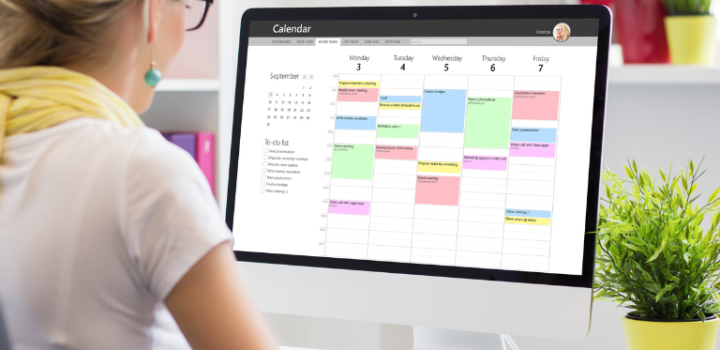 scheduling assistant shown on a screen and a businesswoman is looking at it in her office