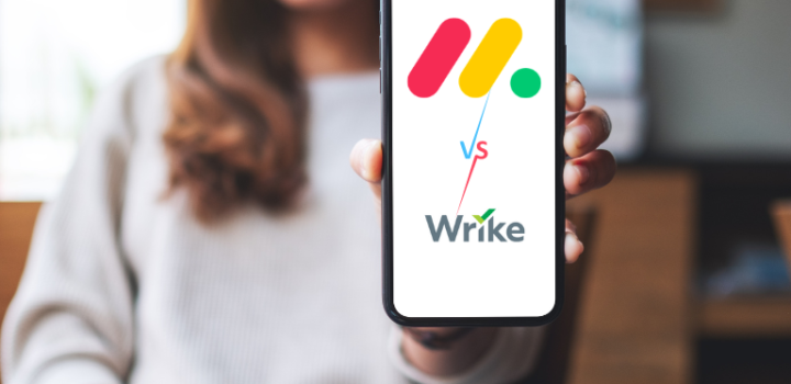 young businesswoman holding a monday vs wrie written on her phone showing the comparison between the two tools